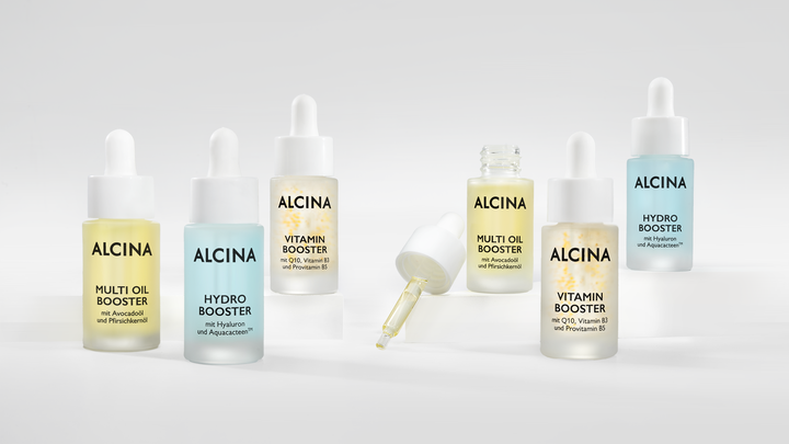 Je zwei Pipettenflaschen von Alcina Multi Oil Booster, Hydro Booster und Vitamin Booster mit dargestellter Serum-Pipette zur Gesichtspflege auf Podesten drapiert